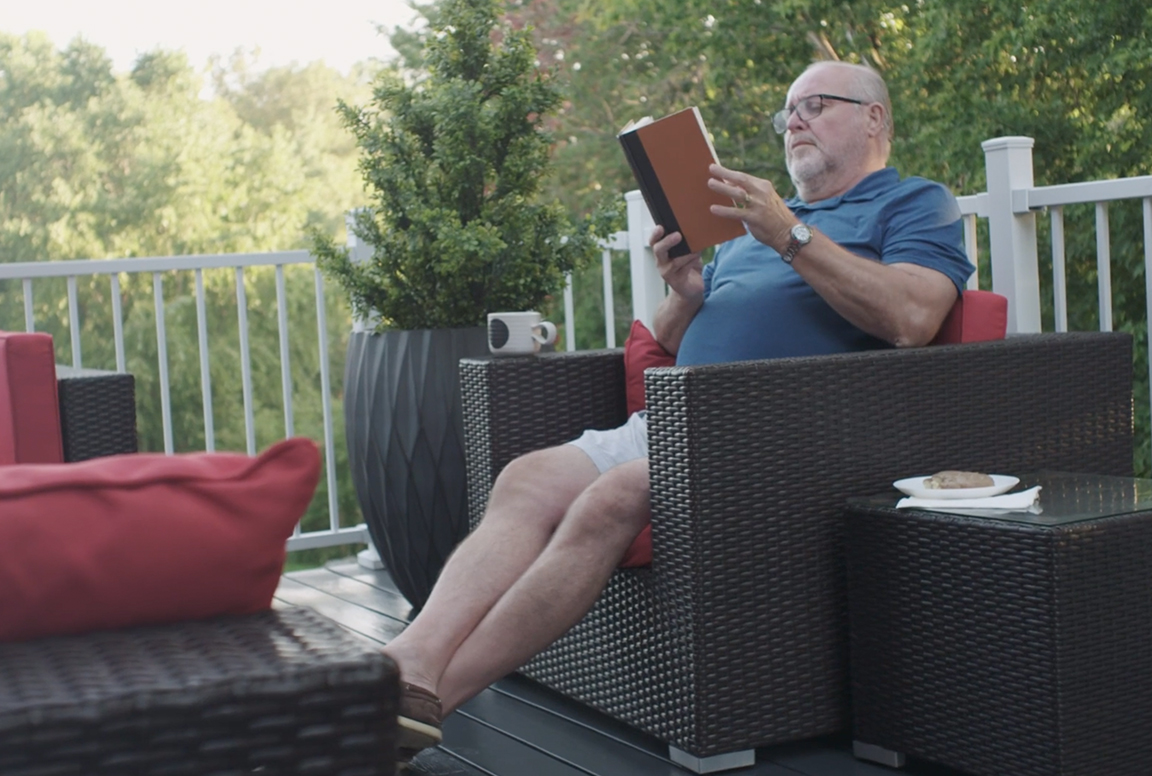 Man Sitting on Deck Reading